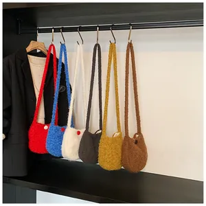 Variété de sacs bandoulière en peluche colorés suspendus en rouge, bleu, blanc, noir