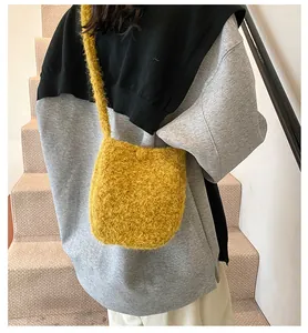 Sac bandoulière en peluche jaune gingembre porté sur un manteau d'hiver gris