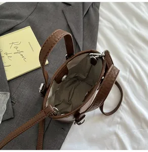 Overhead view showing the spacious interior and brown litchi grain texture of the bucket bag