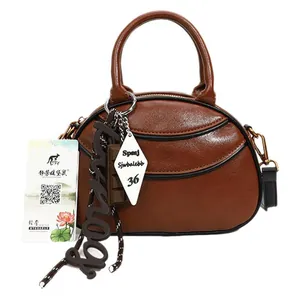 Brown half-moon vintage crossbody bag with polished PU leather and decorative charms