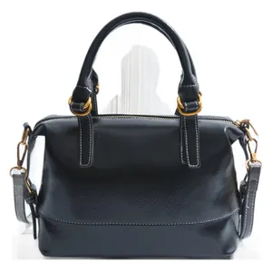 Classic black leather Boston handbag with gold hardware and top handles in minimalist studio setting