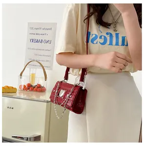 Gros plan du sac à main rouge à texture crocodile doté d'une boucle coeur argentée chic