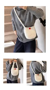 Vue détaillée du sac à bandoulière en peluche blanche avec bouton décoratif rouge