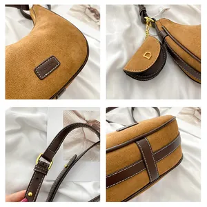 Detail view of suede crescent bag showing leather edges, gold hardware, and mini pouch