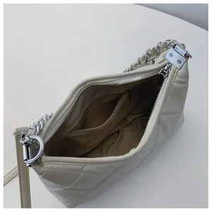 Internal view showing zipper pocket and spacious main compartment of cream quilted bag