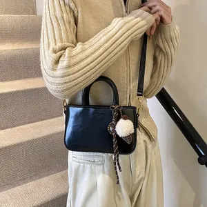 Sac à main en cuir noir brillant avec poignées rondes et charm crème glacée