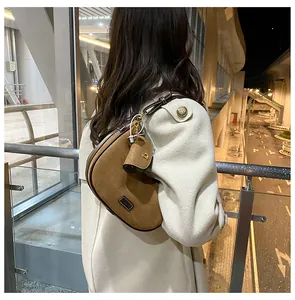 Detail of a brown frosted leather crescent bag with a mini round coin purse and D-ring