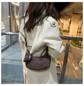 Street style view of a brown frosted leather crescent bag with a mini round coin purse