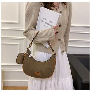 Detail of frosted leather crescent bag with detachable mini pouch and fashion label