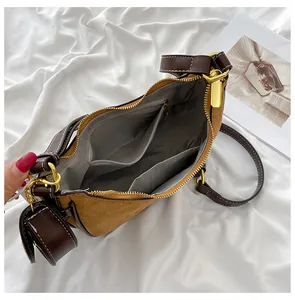 Detail view of the brown leather crescent bag with herringbone lining and zip pocket