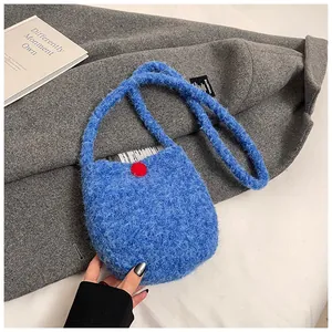 Gros plan sur la texture du sac en peluche bleu klein avec un détail de point rouge