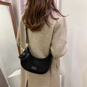 Retro black matte suede crescent shoulder bag with D-letter charm shown on a model