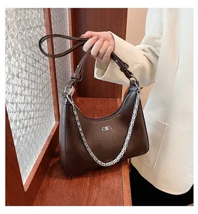 Detail of vintage brown leather underarm bag with silver chain and metal hardware