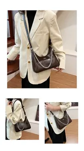 Detail view of coffee brown hobo bag with crackle texture and silver chain strap