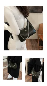 Detailed view of dark green hobo bag with glossy leather texture and silver BB chain