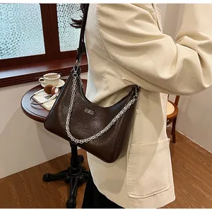 Close-up of dark brown leather hobo bag with vintage texture and silver chain detail