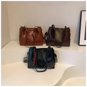 Dettaglio di grandi borse tote in tre colori con ampie tracolle in tessuto intrecciato