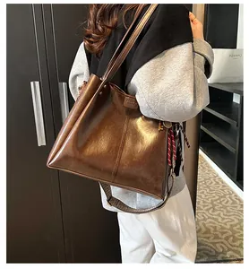 Dettaglio borsa tote vintage marrone con sciarpa a righe e tracolla larga