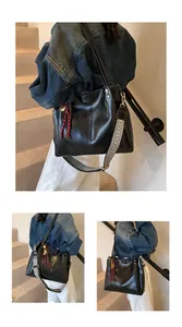 Dettaglio borsa tote in pelle nera con tracolla larga a motivo geometrico intrecciato