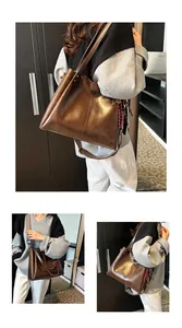 Dettaglio della borsa tote marrone vintage con tracolla tessuta e pelle lucida