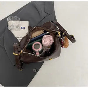 Macro view of a large brown shoulder bag showing spacious interior with daily essentials