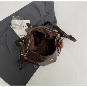 Detailed interior of dark brown leather tote bag with pockets and golden magnetic buckle