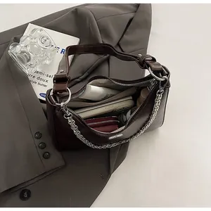 Internal view of dark brown underarm bag showing space for phone and makeup