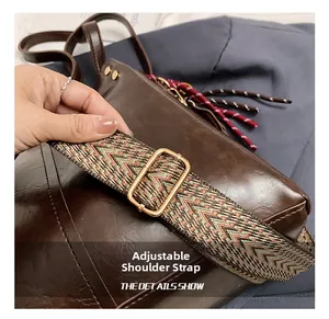 Detalle de correa tejida ajustable en un bolso tote marrón retro con hebilla dorada