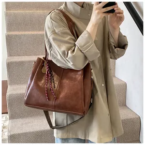 Dettaglio della borsa tote marrone vintage con sciarpa decorativa e tracolla geometrica