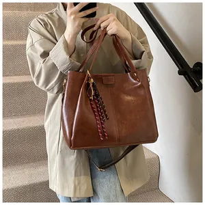 Dettaglio borsa tote vintage marrone con tracolla larga e ciondolo in corda intrecciata