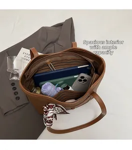 Top view of spacious brown leather tote bag interior with tablet, phone, and umbrella