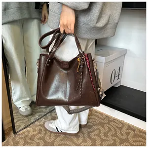 Dettaglio della borsa tote vintage marrone con goffratura moda e tracolla larga intrecciata