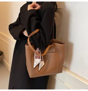 Detail of brown leather tote bag with lychee texture and heart pattern silk scarf