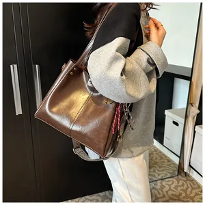 Vista dettagliata della grande borsa tote retrò marrone scuro con tracolla larga e similpelle