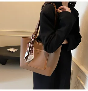 Detailed view of brown lychee texture leather tote bag with a silk scarf and front snap pocket