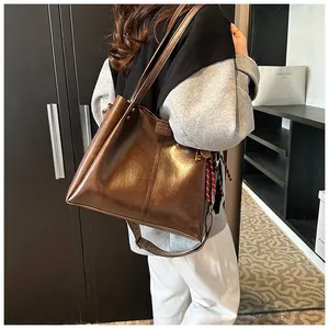 Dettaglio della grande borsa tote vintage in pelle lucida marrone con tracolla