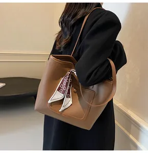 Brown litchi grain leather tote bag with printed silk scarf on the handle detail