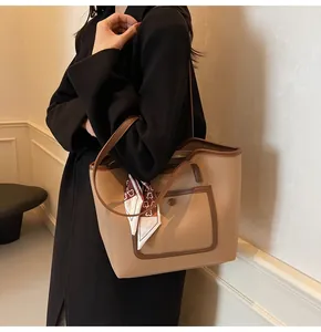 Close-up of khaki pebbled leather tote bag with silk scarf and decorative side pocket