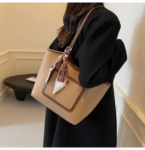 Litchi texture beige and brown tote bag with decorative scarf shown on shoulder