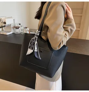 Chic black pebbled leather tote bag for women with decorative bear print scarf on handle