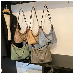 Detailed display of multi-color vintage suede tote bags with chic metal chains
