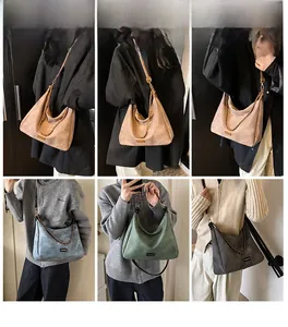 Close-up of suede crossbody tote bags in brown, blue, and green with metallic chains