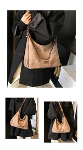 Detail of vintage suede tote bag with bronze chain and leather fashion tag