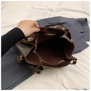 Dettaglio della borsa tote marrone con tasca interna a zip e tracolla con fantasia