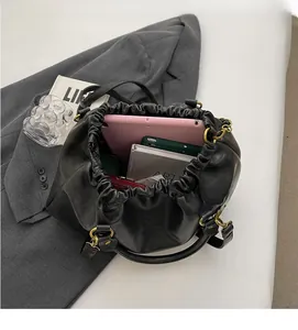 Interior view of black pleated dumpling bag showing tablet and essentials storage