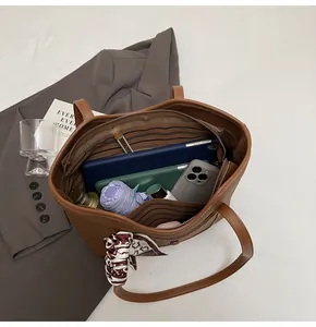 Spacious brown leather tote bag interior showing capacity for tablets and essentials
