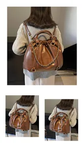 Detail view of brown pleated faux leather handbag with gold chain and soft texture