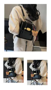 Détails du sac à dos en similicuir noir avec logo doré et pendentif ours mignon