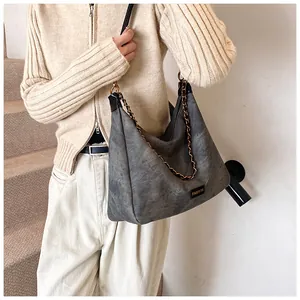 Detail of vintage grey faux suede tote bag with chain strap and fashion label detail