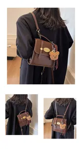 Détail du sac à dos vintage marron avec boucle métallique et breloque ourson